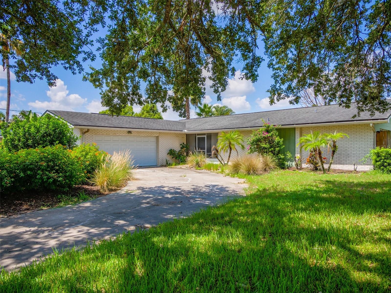 Front exterior of the mid century ranch with landscaping and circular drive