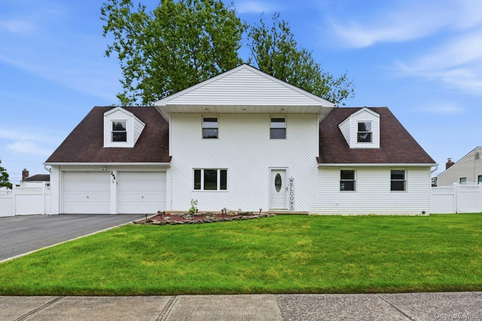 Two-story residence featuring white vinyl siding and a dark shingle roof