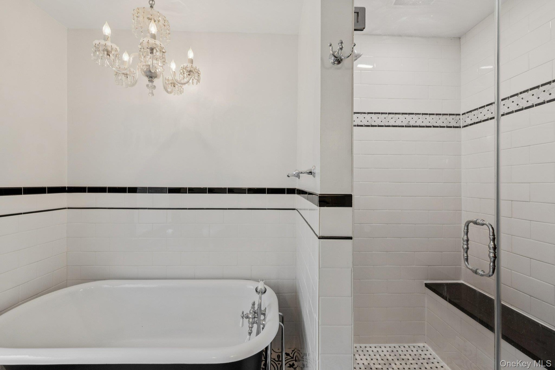 Bathroom featuring a freestanding bath, a stall shower, and tile walls