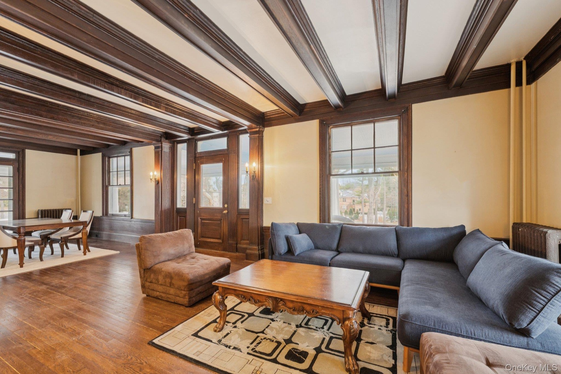 Living room with beam ceiling, hardwood / wood-style flooring, and crown molding