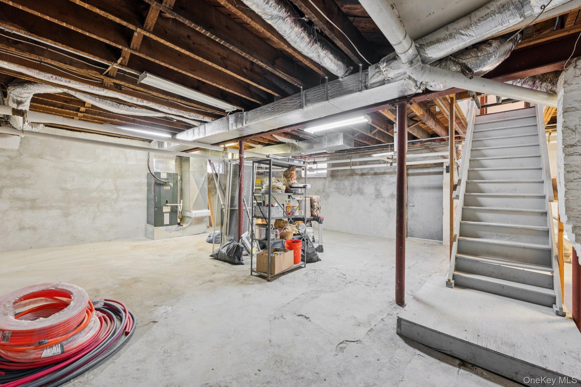 Unfinished below grade area featuring stairway