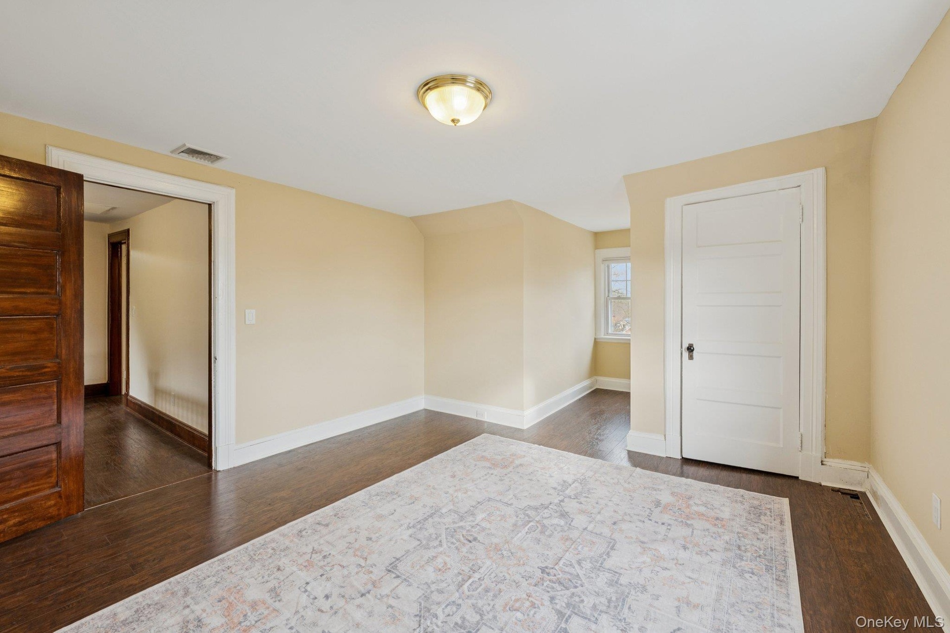 Empty room featuring baseboards and dark wood-style flooring