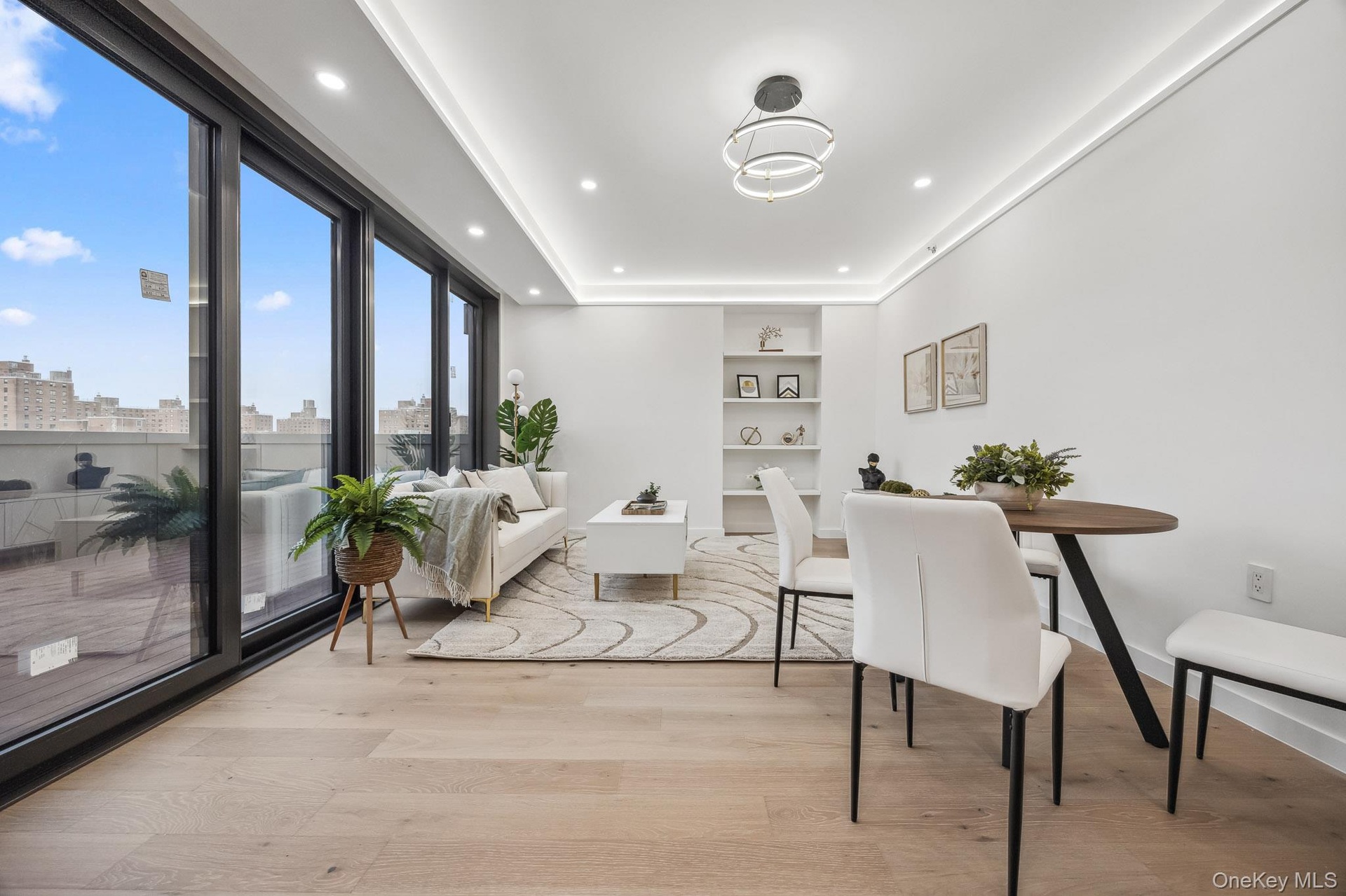 Dining area with built in shelves, light wood-type flooring, baseboards, recessed lighting, and a view of city
