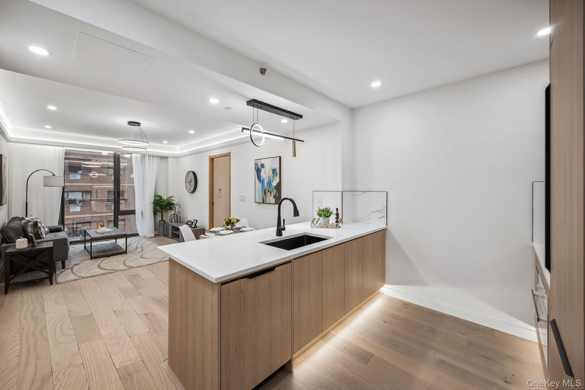 Kitchen with a sink, modern cabinets, light wood-style flooring, a peninsula, and open floor plan