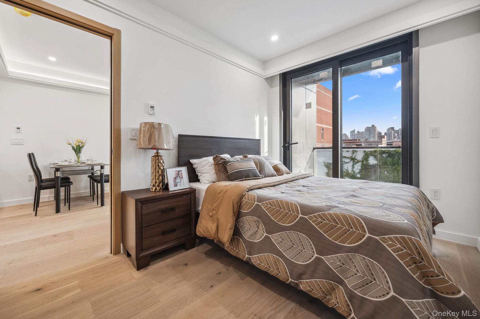 Bedroom featuring light wood-type flooring, a skyline view, recessed lighting, access to outside, and baseboards