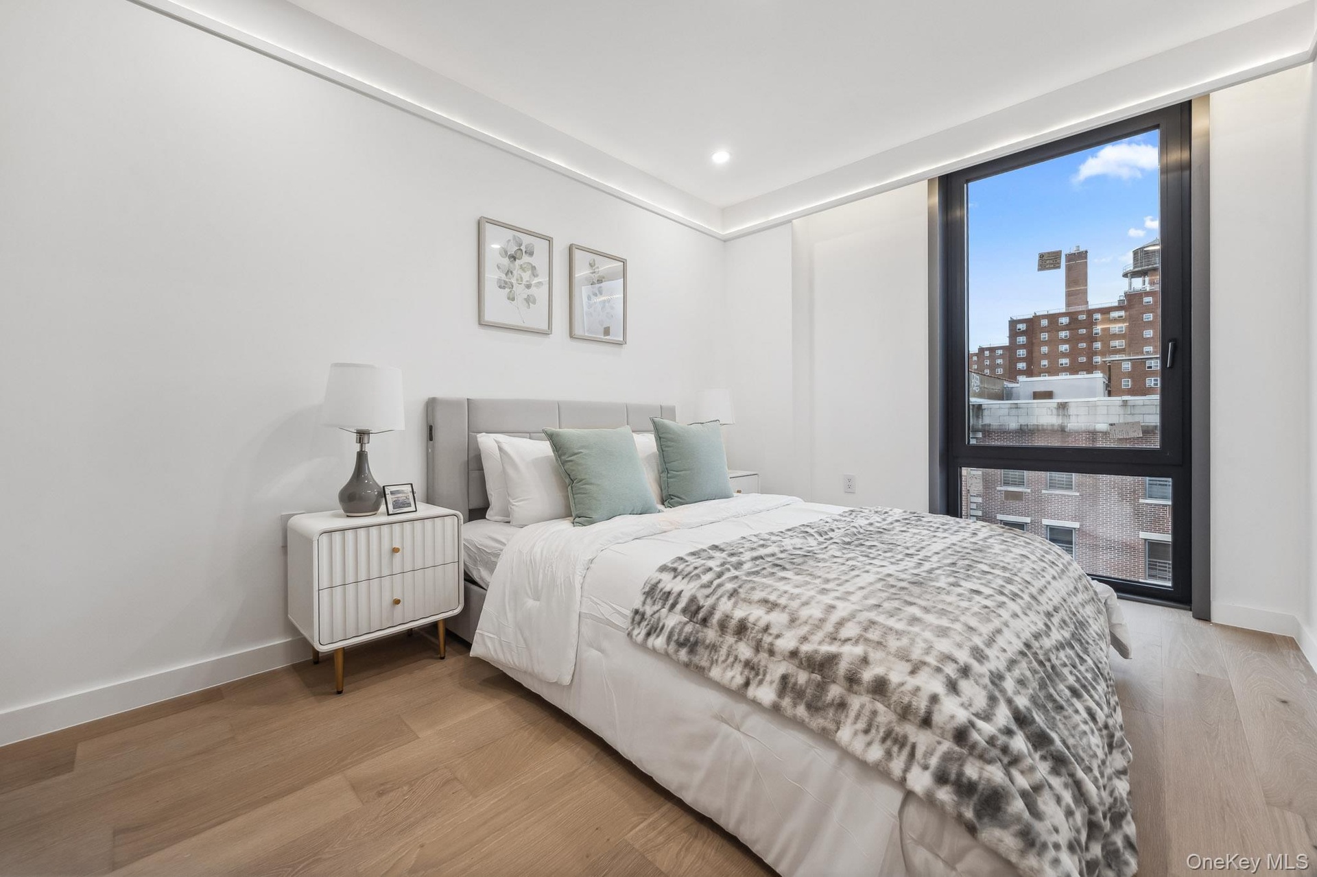 Bedroom featuring light wood-style flooring, baseboards, recessed lighting, and a view of city