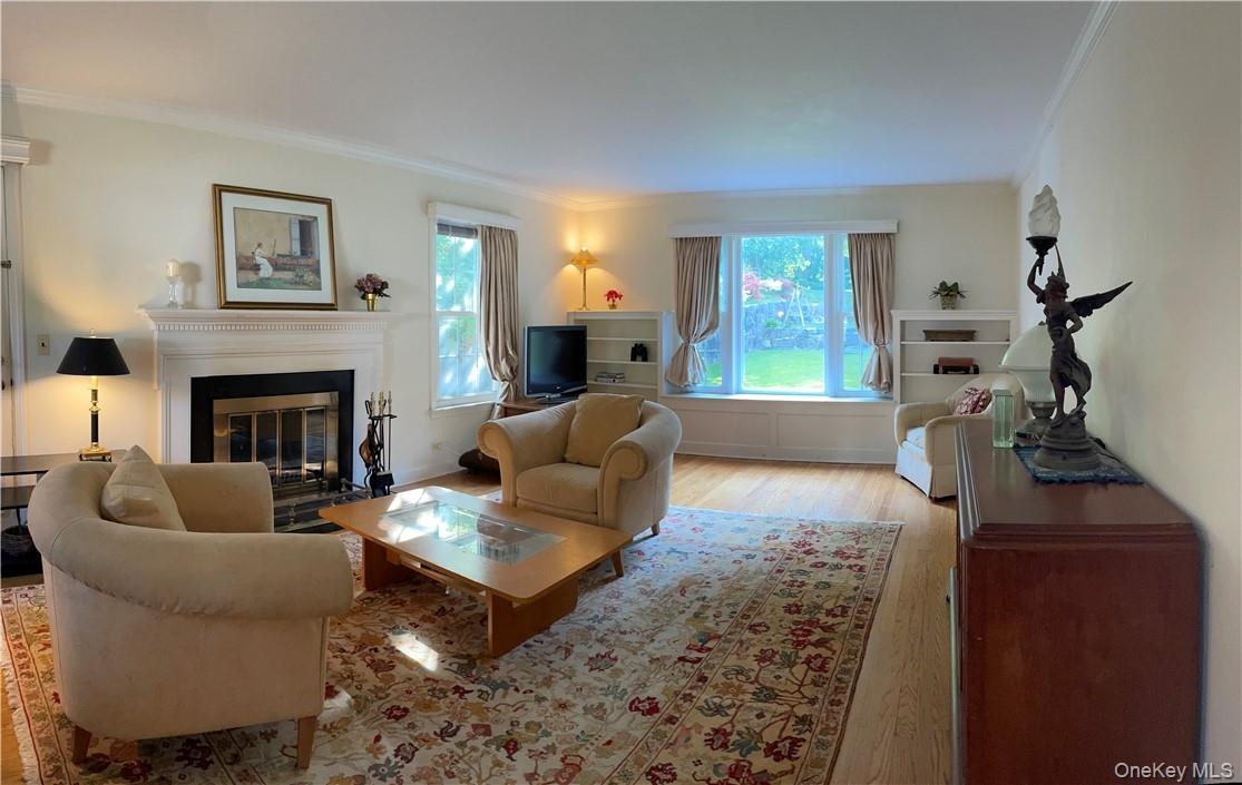 View of the formal living room with bay window and wood burning fireplace