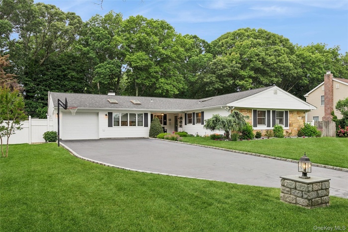 Contemporary ranch-style residence featuring a combination of white siding and stone facade