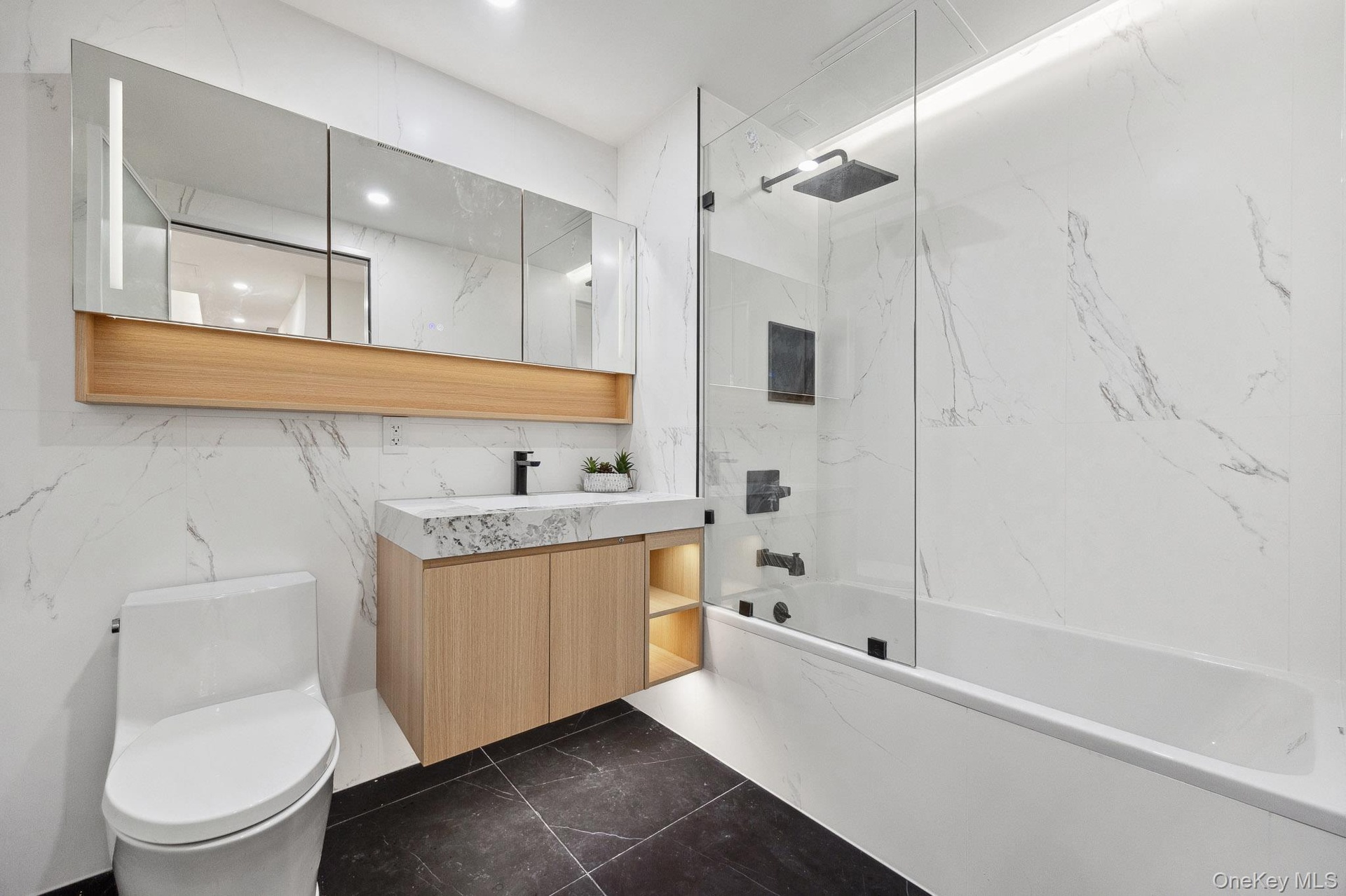 Full bath with toilet, bathing tub / shower combination, vanity, marble finish flooring, and recessed lighting