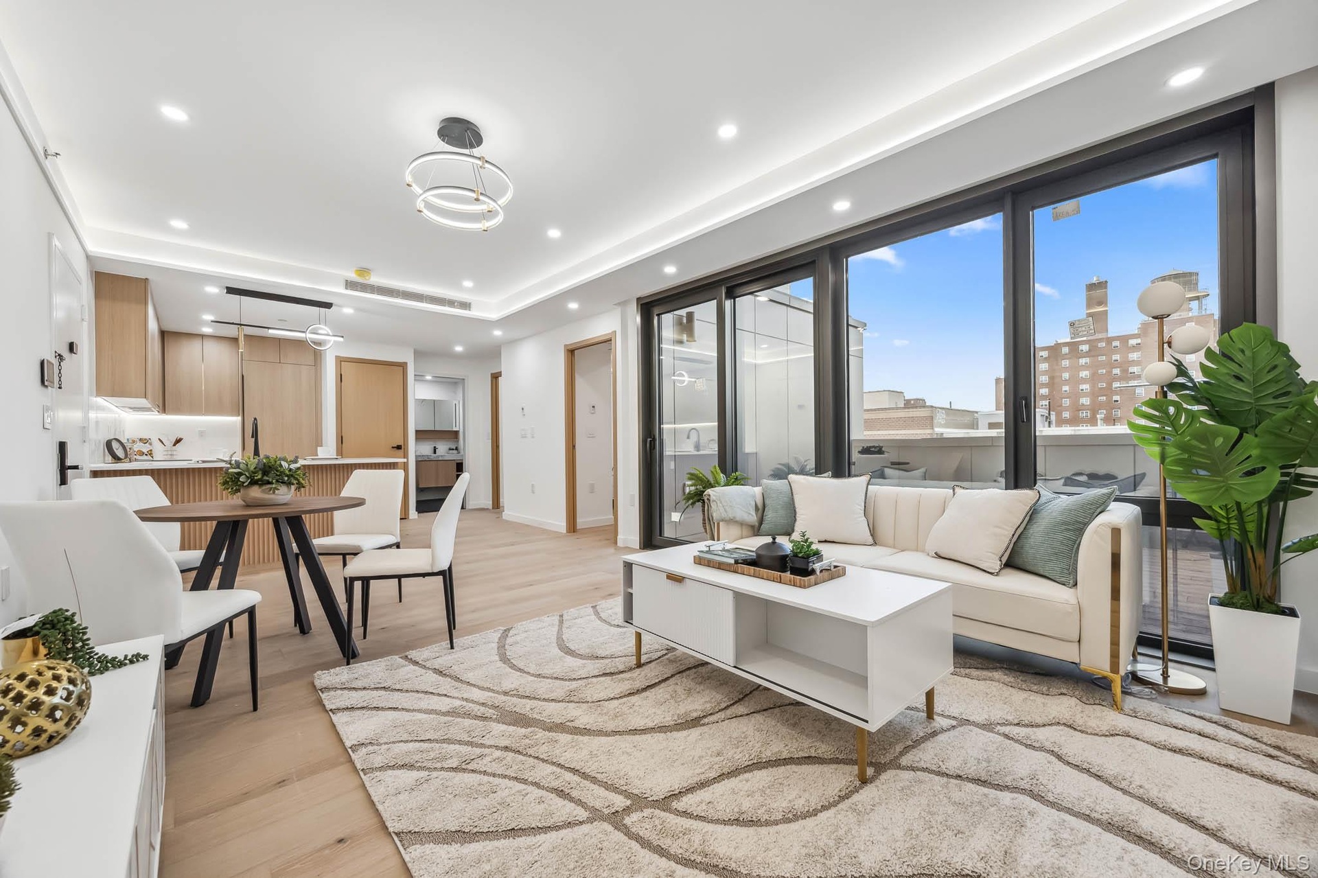 Living room with light wood-style floors, recessed lighting, baseboards, and a tray ceiling