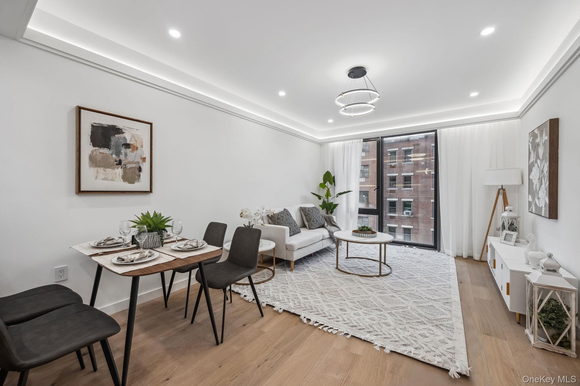 Living room featuring wood finished floors, recessed lighting, and a tray ceiling