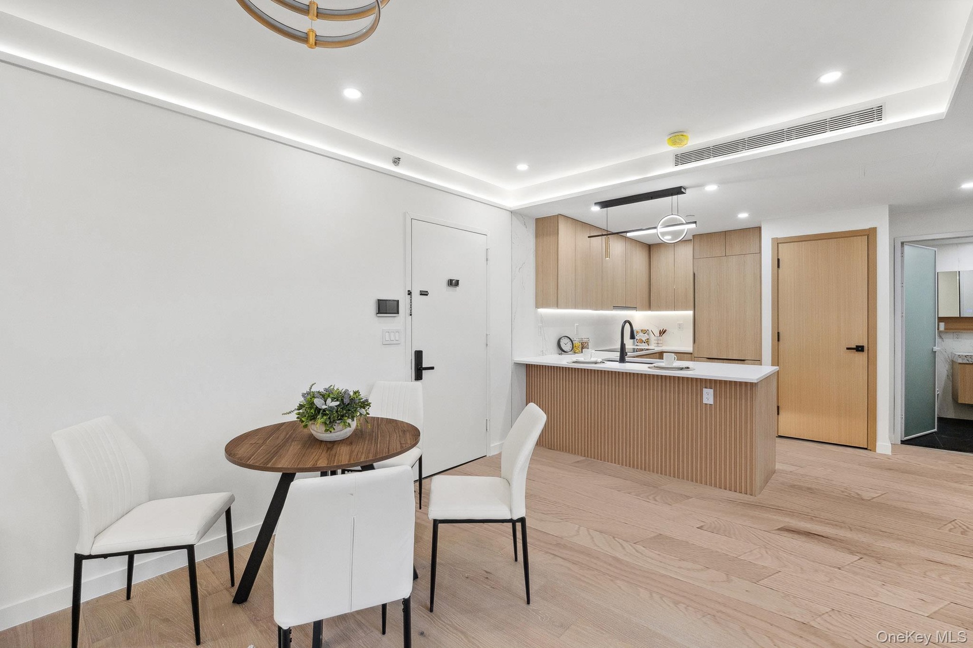 Dining room with light wood finished floors and recessed lighting