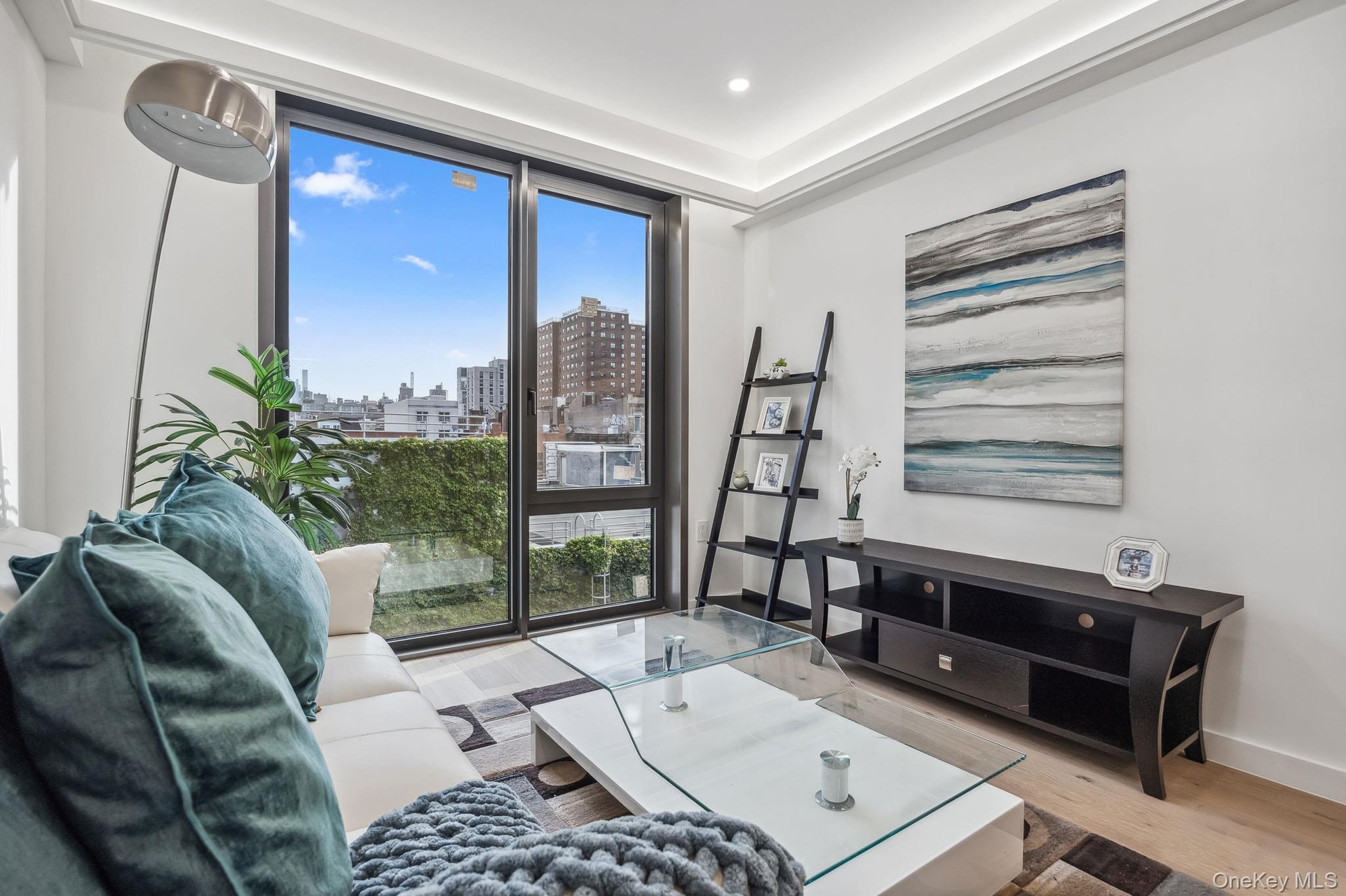 Living room with a view of city, healthy amount of natural light, wood finished floors, recessed lighting, and baseboards