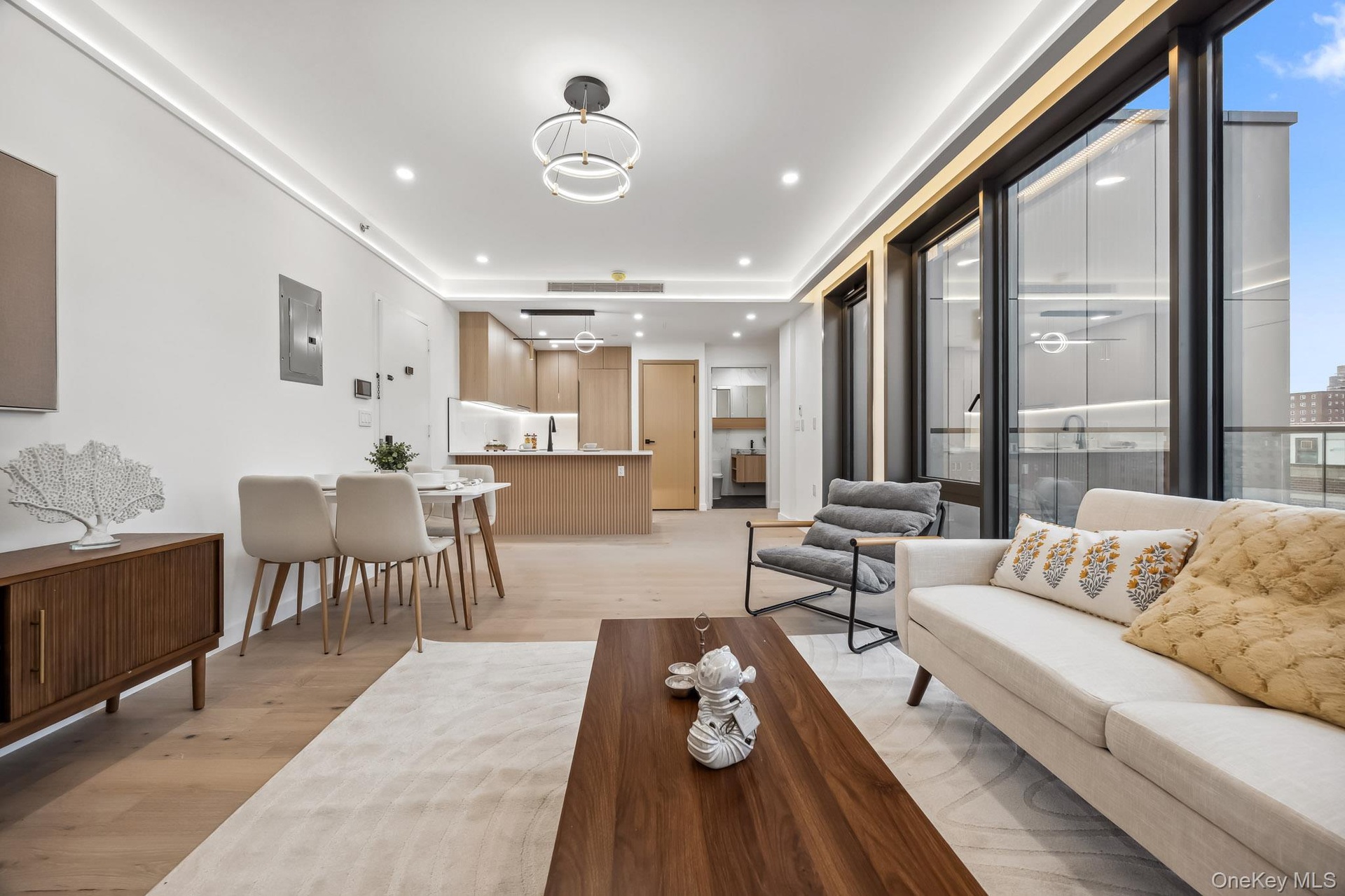 Living room featuring light wood finished floors, recessed lighting, and electric panel