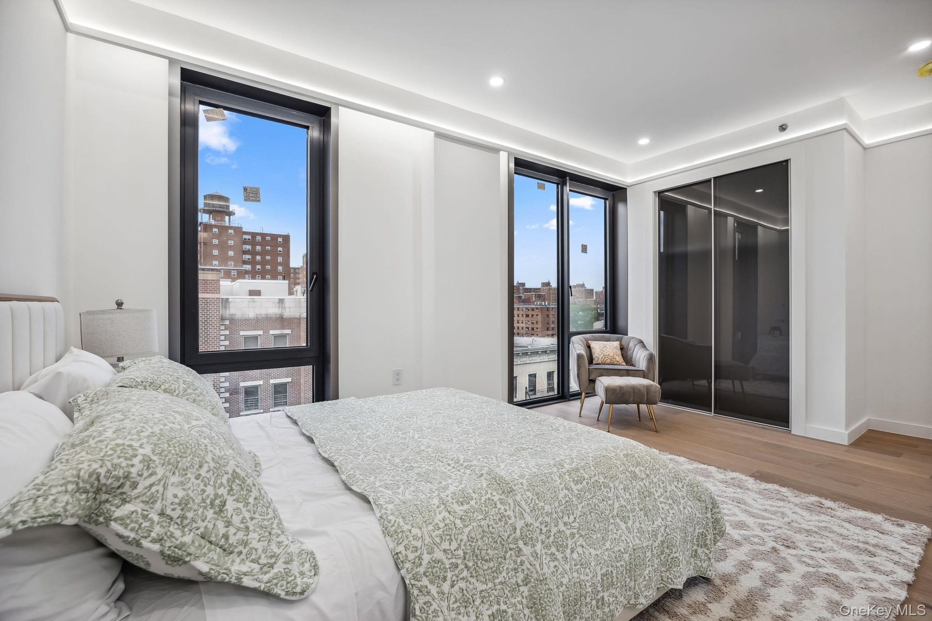 Bedroom featuring wood finished floors, radiator, a city view, recessed lighting, and baseboards