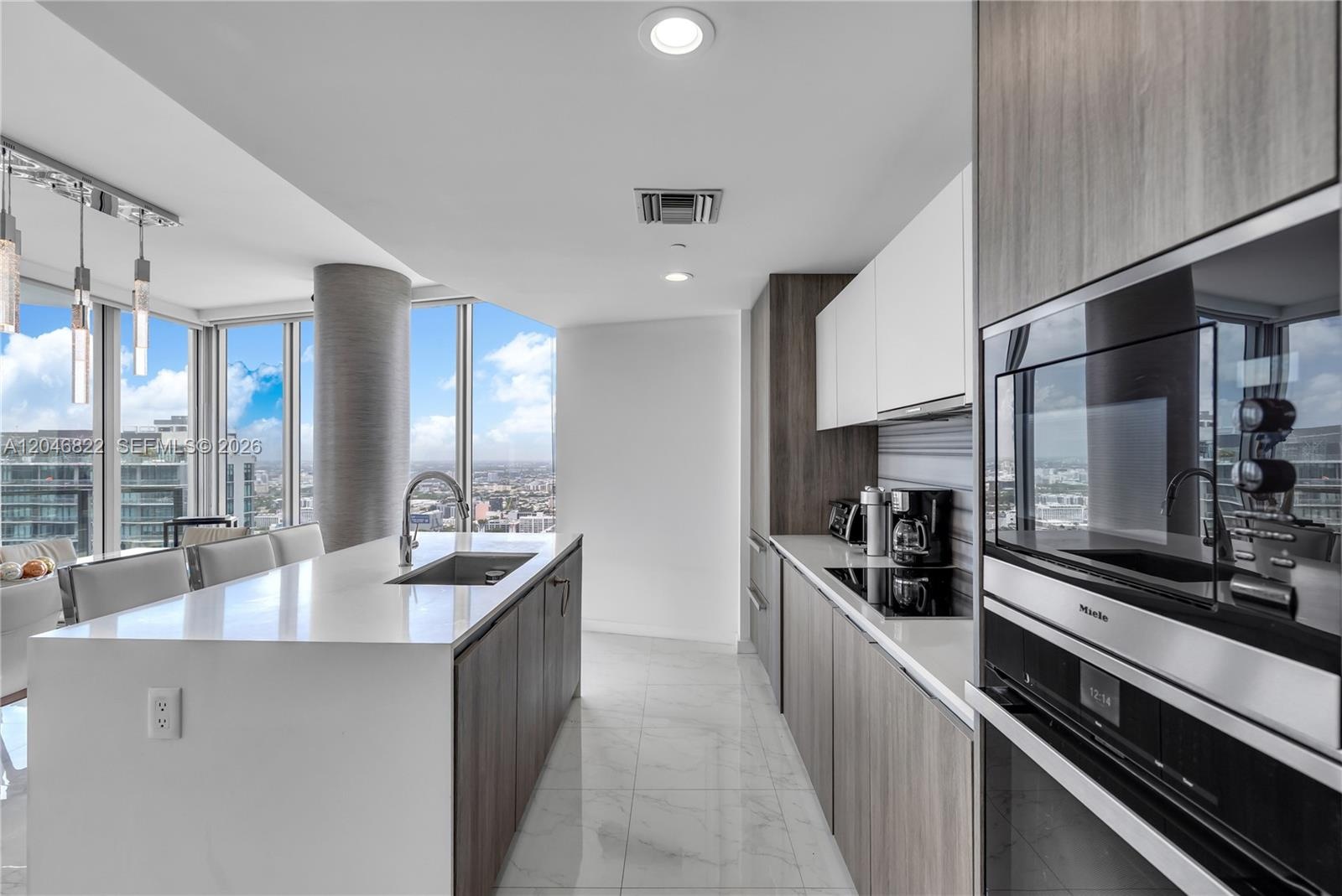 Sleek open kitchen with breakfast bar seating and premium finishes
