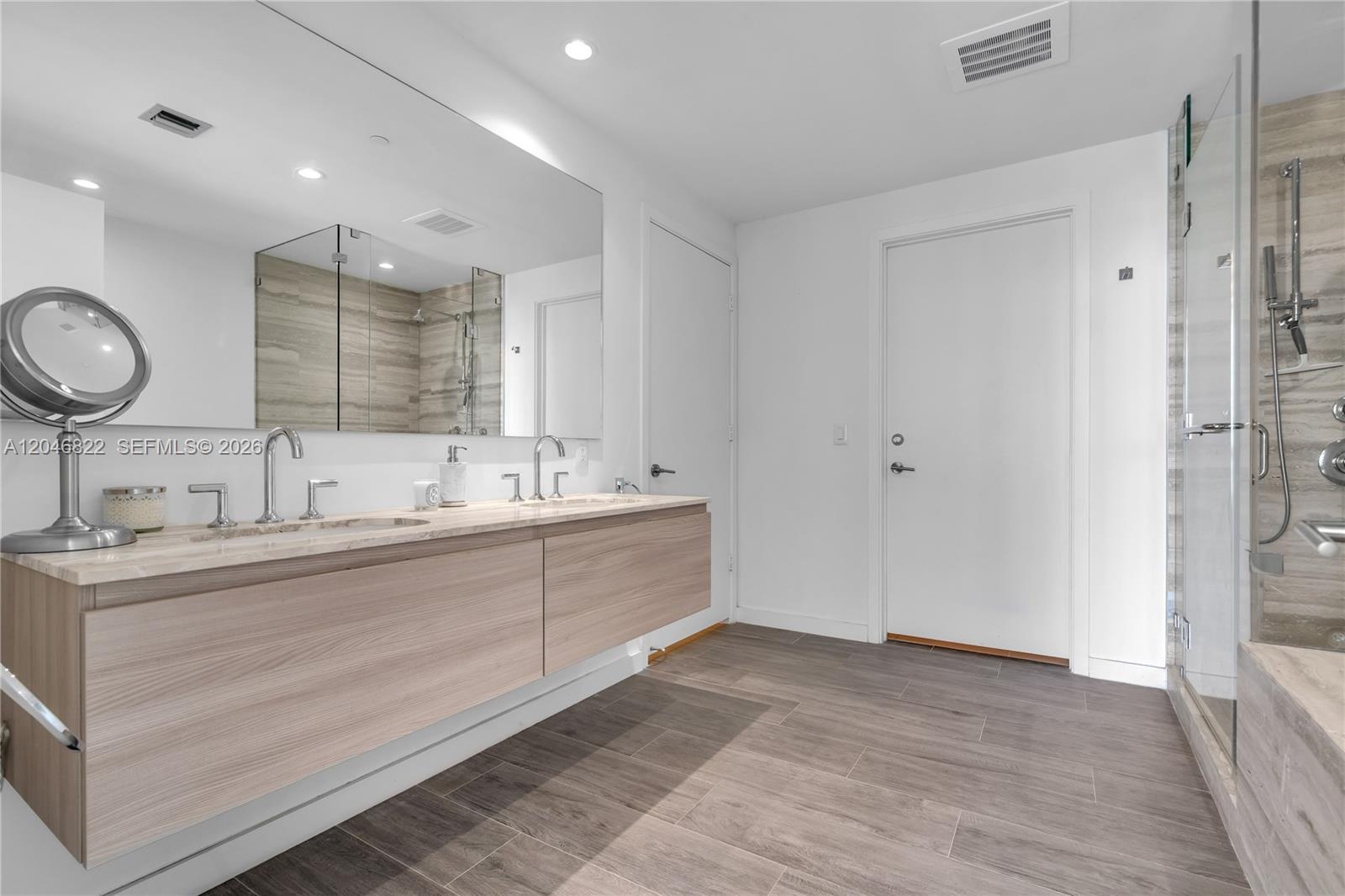Primary bath with dual vanities, soaking tub, and walk-in shower