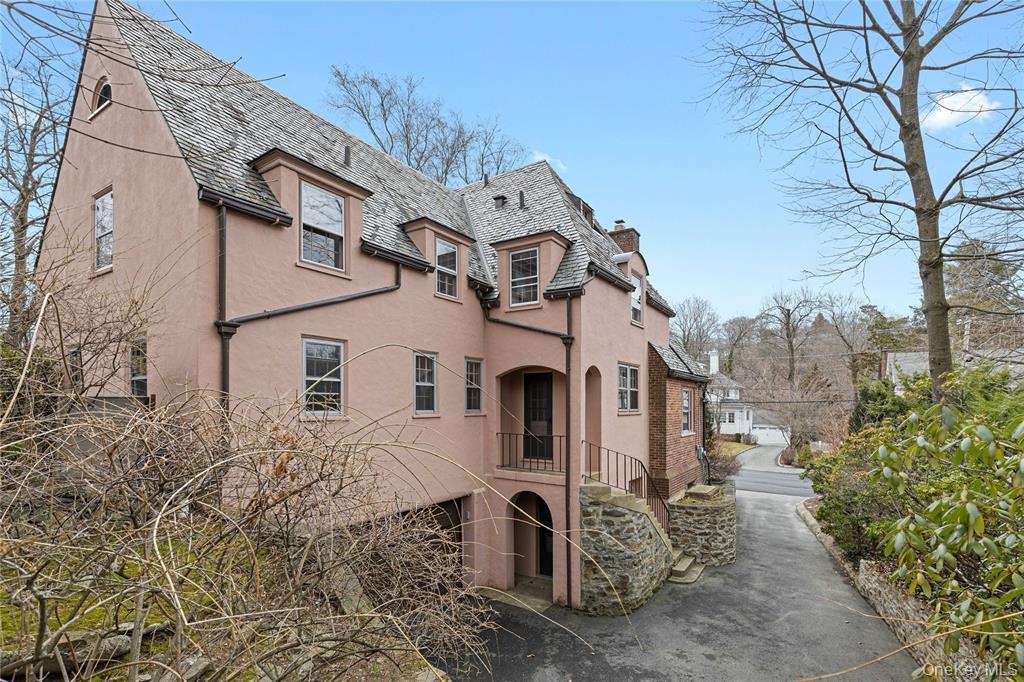 View of home's exterior with stairs, a chimney, and stucco siding