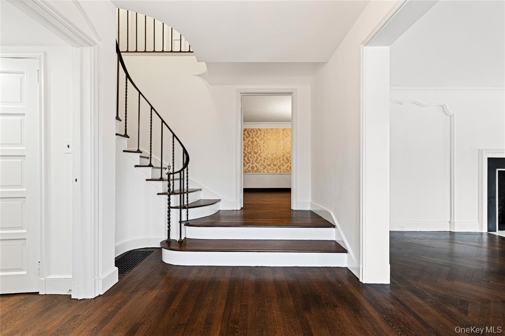 Stairs with wood finished floors, visible vents, and baseboards