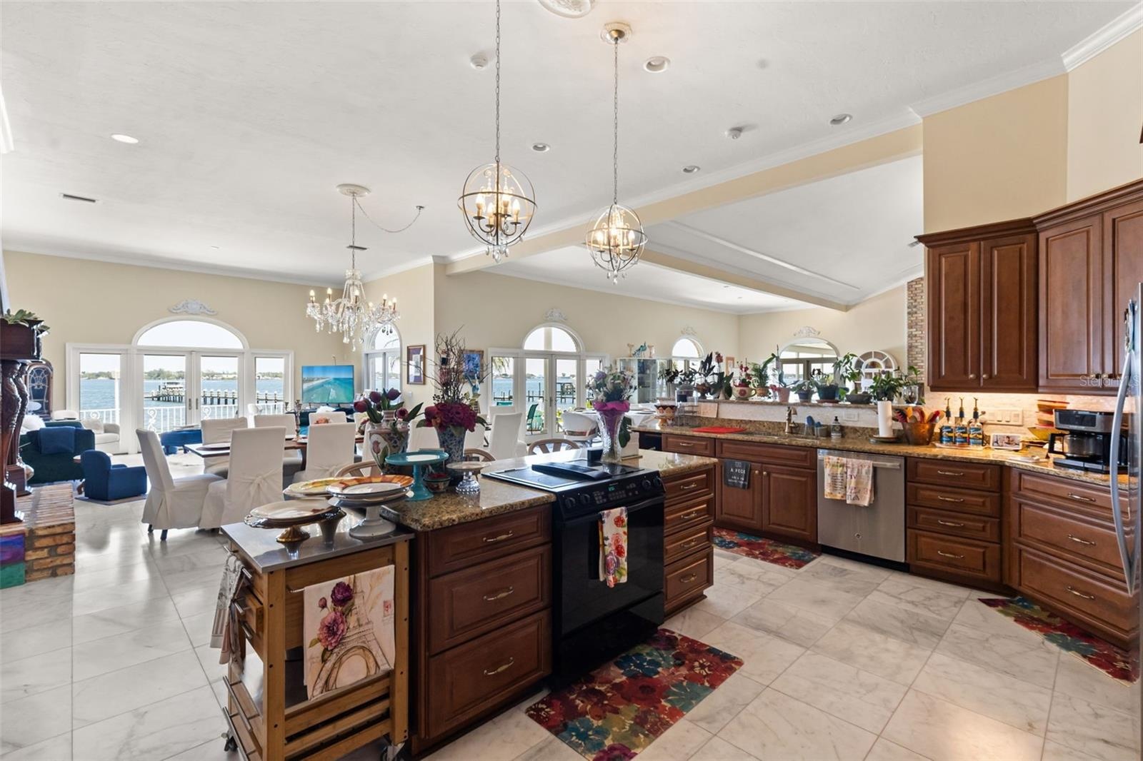 Designed for both luxury and flow, the chef's kitchen showcases stunning panoramic vistas of the Manatee River, extending effortlessly into the media 