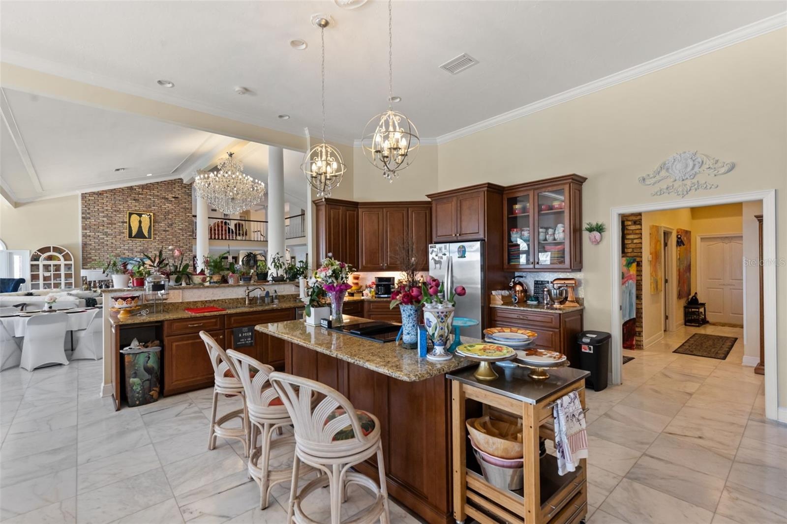 Chef's kitchen flows seamlessly into the grand living room, creating an impressive space for refined living and entertaininmg.