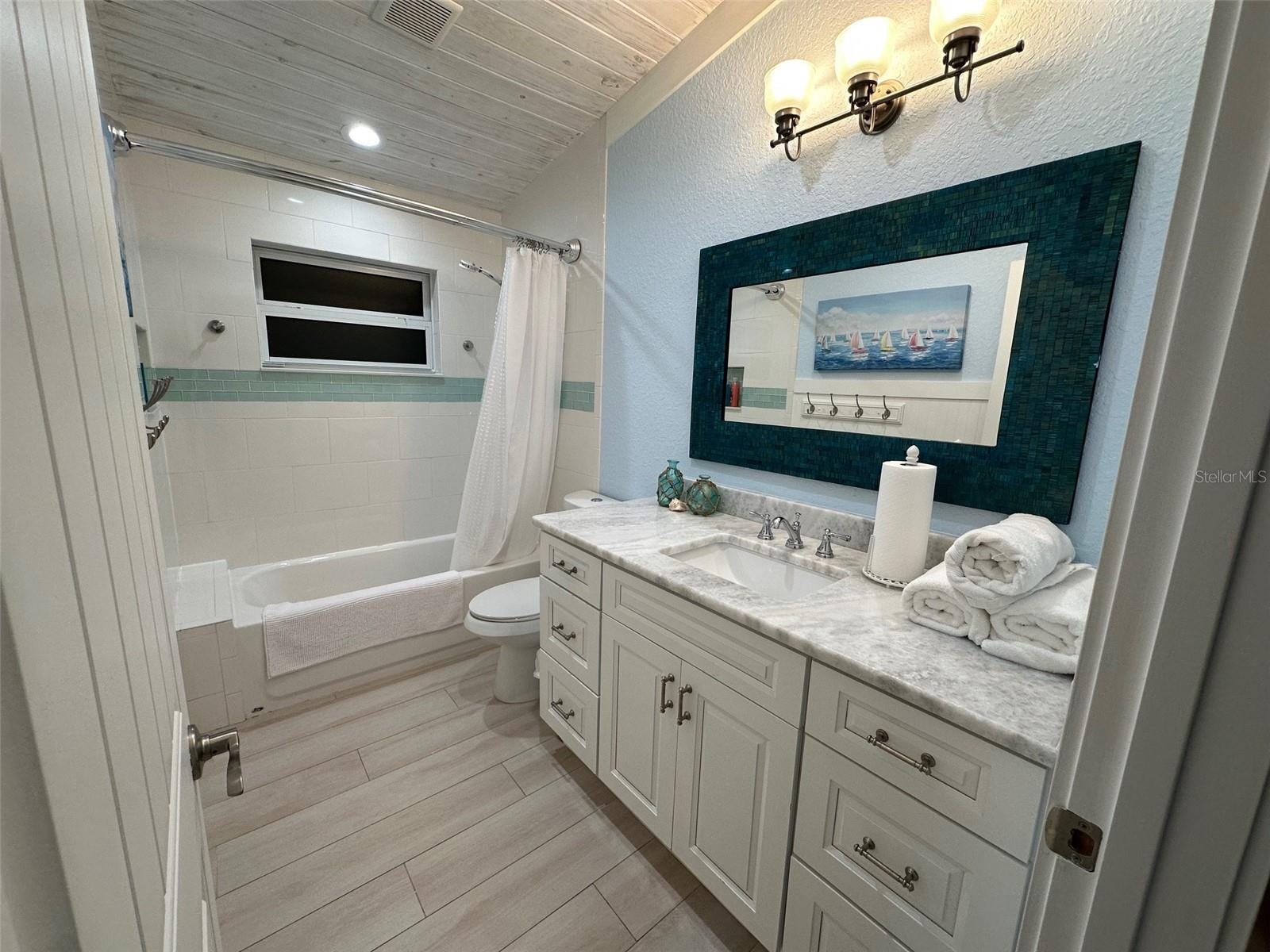 Refreshing and inviting bathroom. Window that allows a gentle breeze. The crisp white tiles and sleek fixtures create a clean and classic aesthetic. A