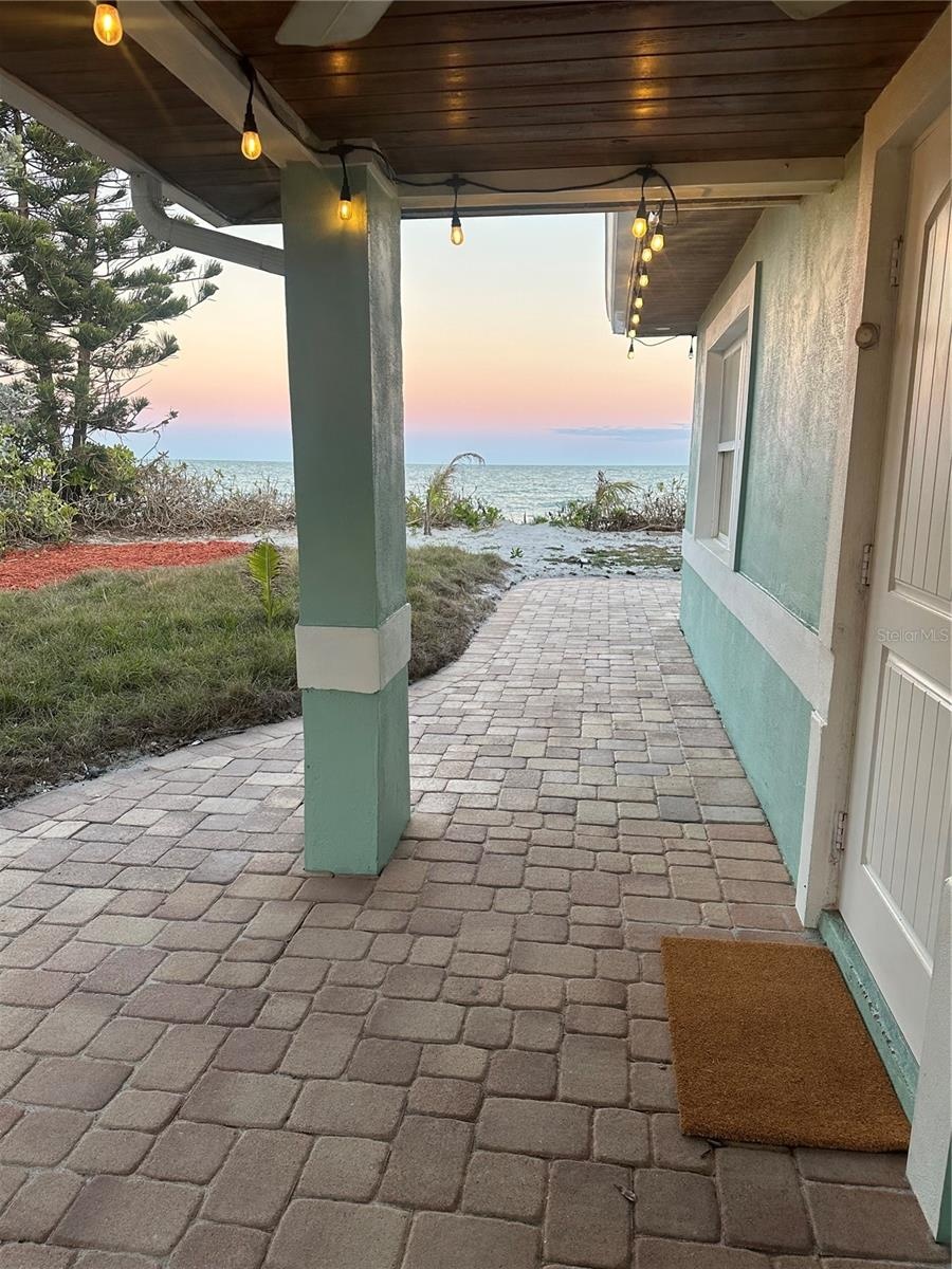 A large 33-foot covered front porch, perfect for relaxing in any weather. with three fans, string lights, wood soffits, and quality oversized chairs, 