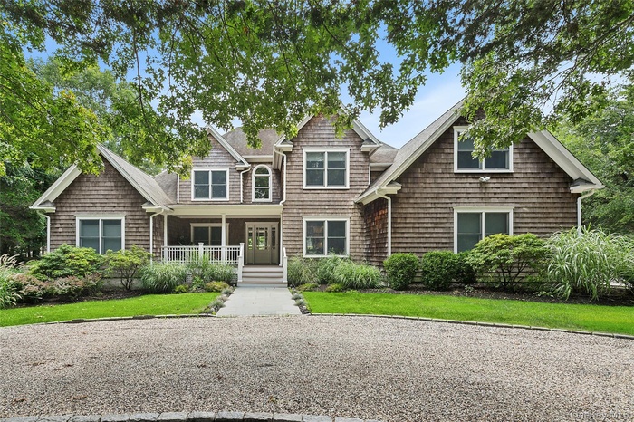 View of front facade featuring covered porch and a front lawn