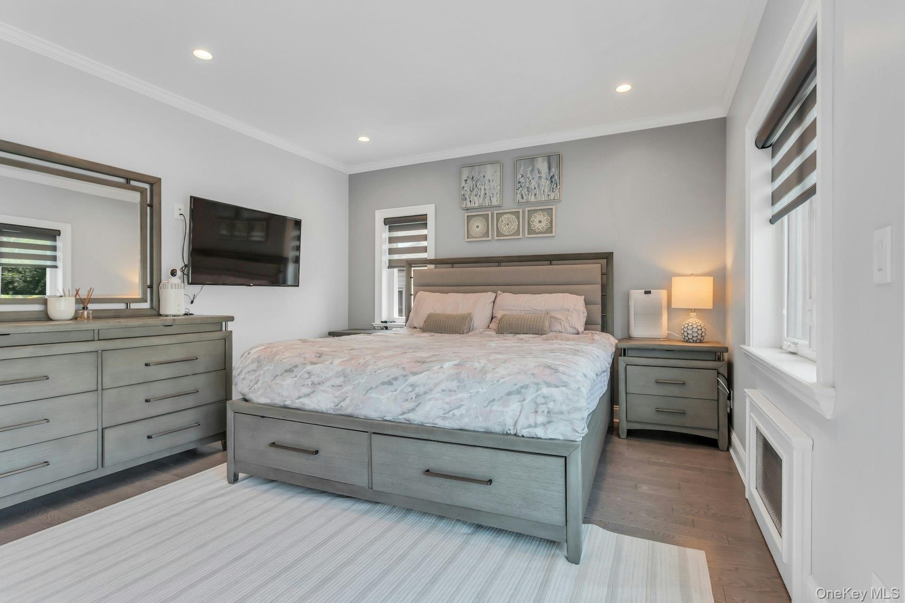 Bedroom featuring wood-finish flooring, recessed lighting, crown molding, and two windows with electric blinds
