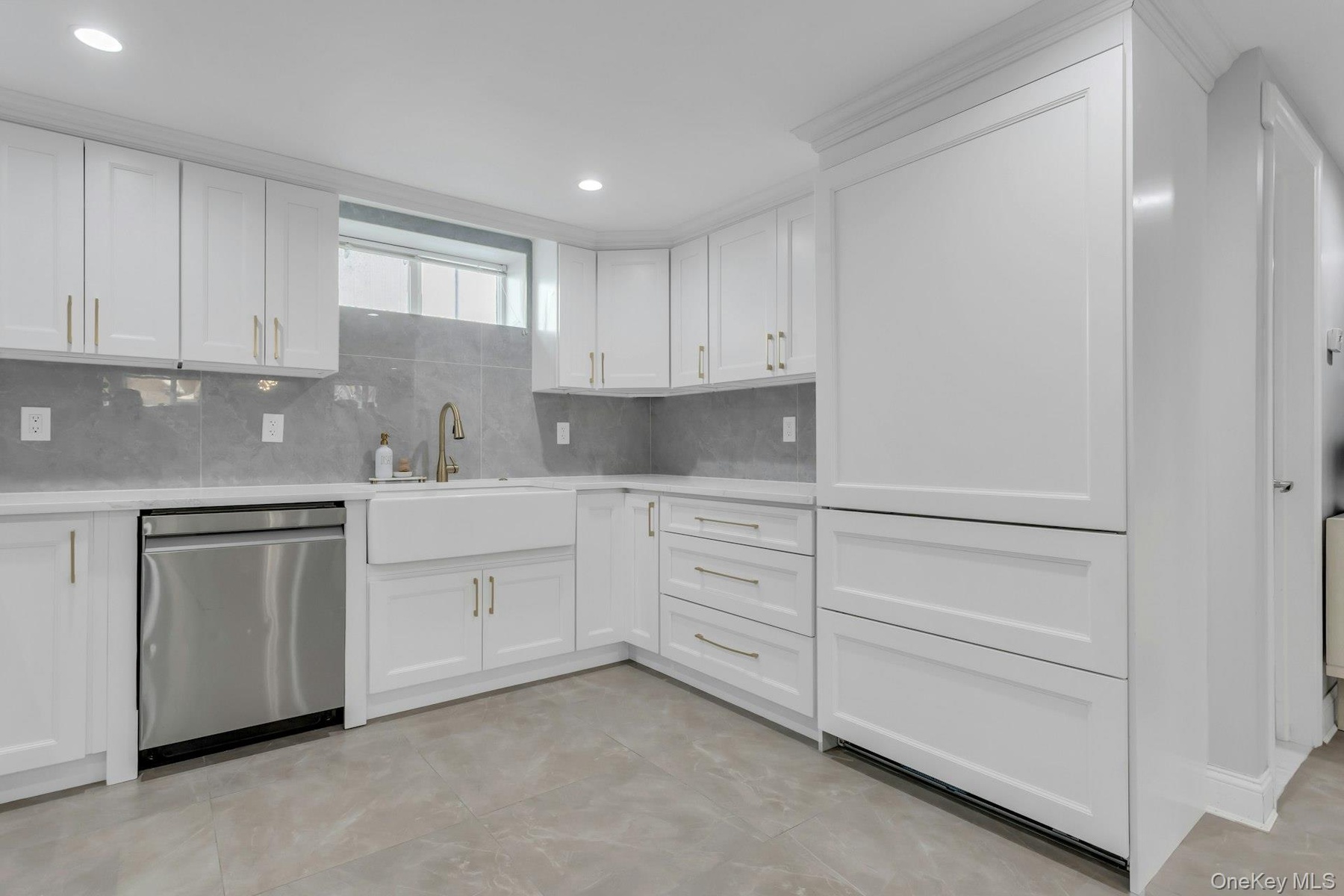 Bonus: Modern kitchen featuring white shaker cabinetry, an integrated white farmhouse sink with a gold-tone faucet, and a stainless steel dishwasher