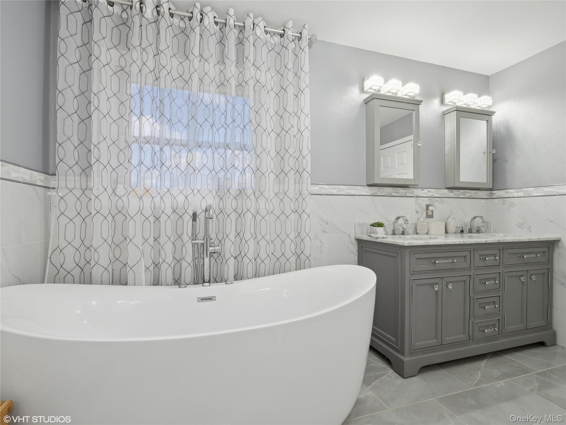 Bathroom featuring a tub, vanity, and tile walls