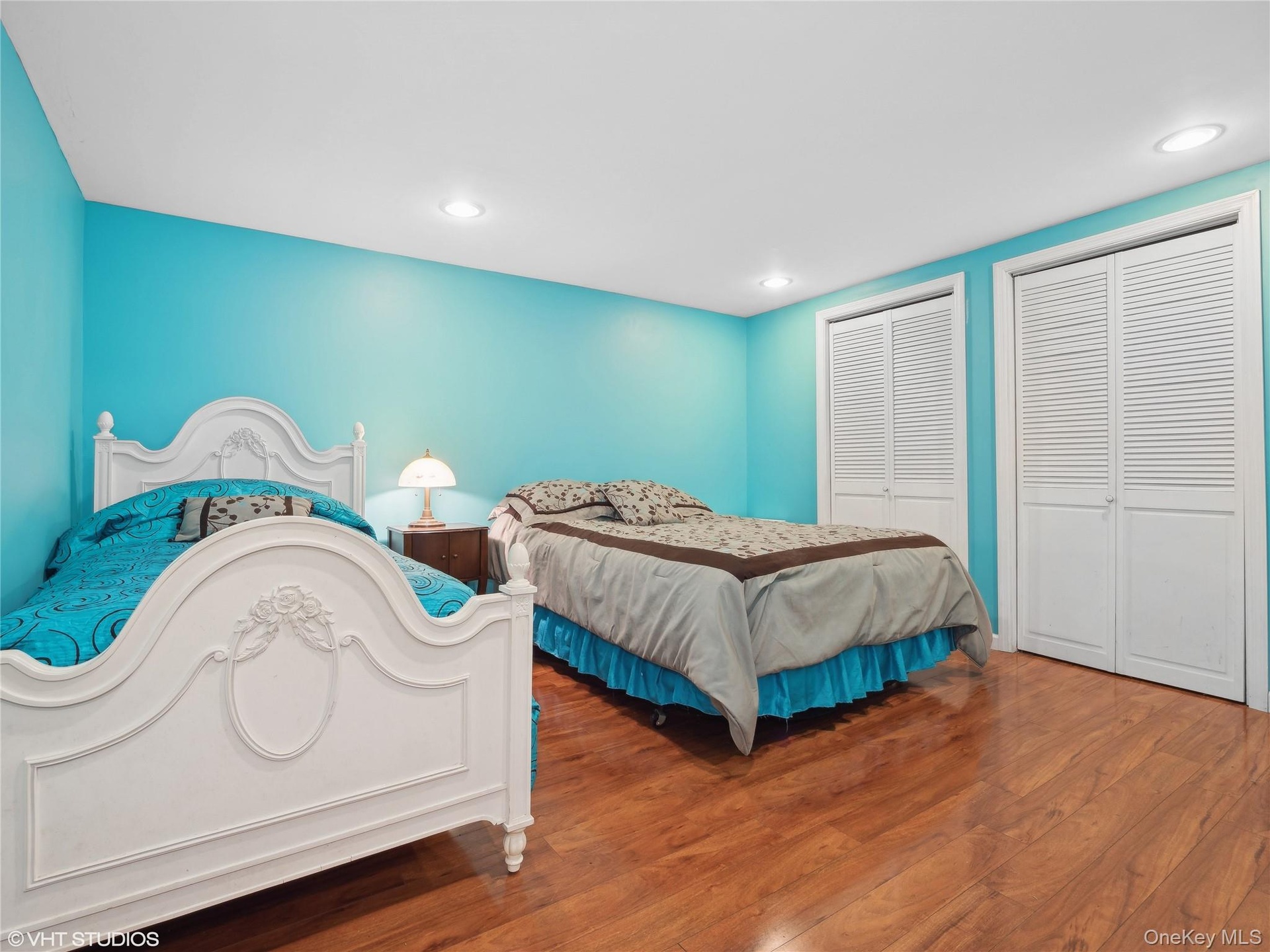 Bedroom with two closets and hardwood / wood-style flooring