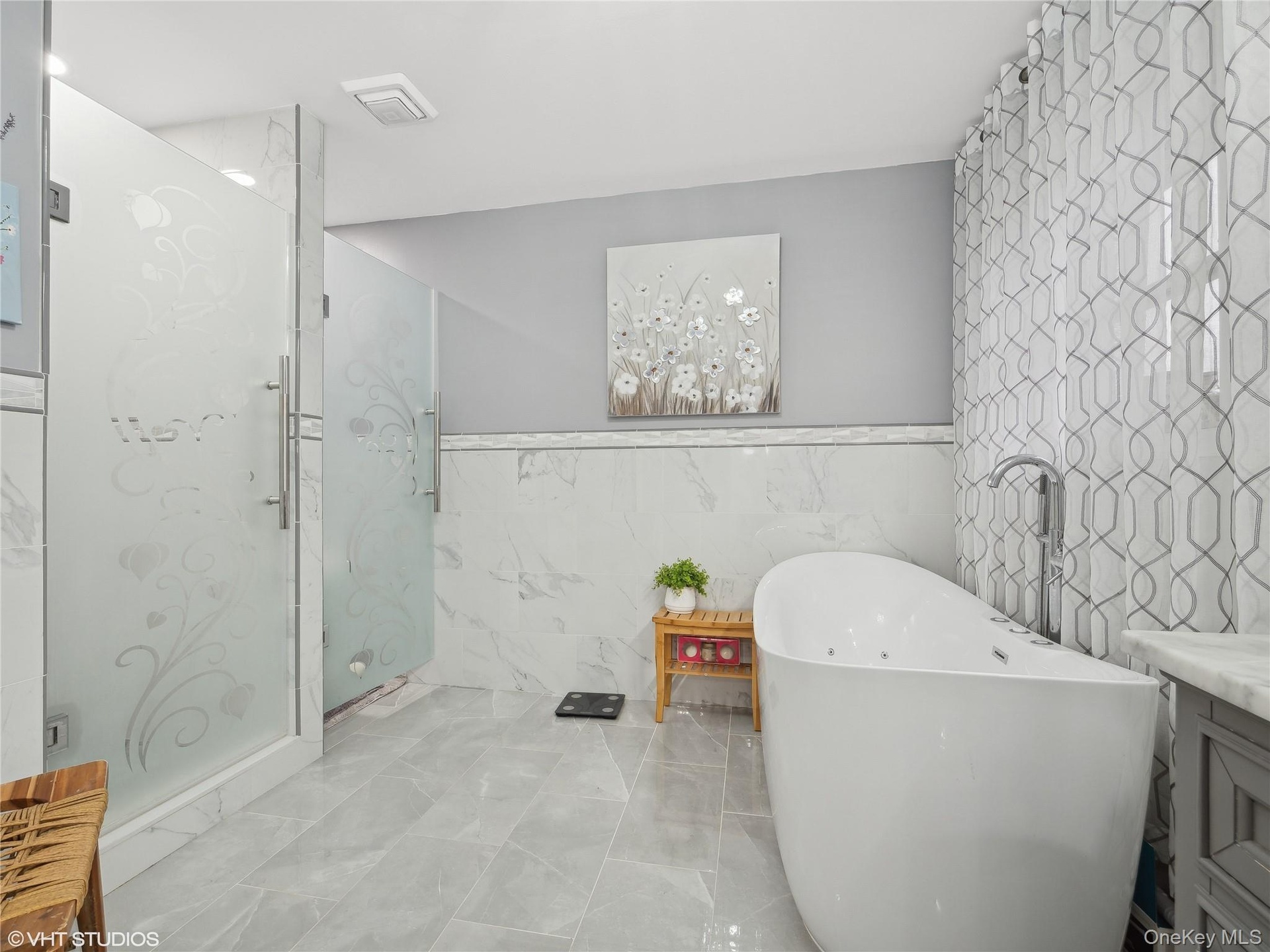 Bathroom with plus walk in shower, vanity, and tile walls