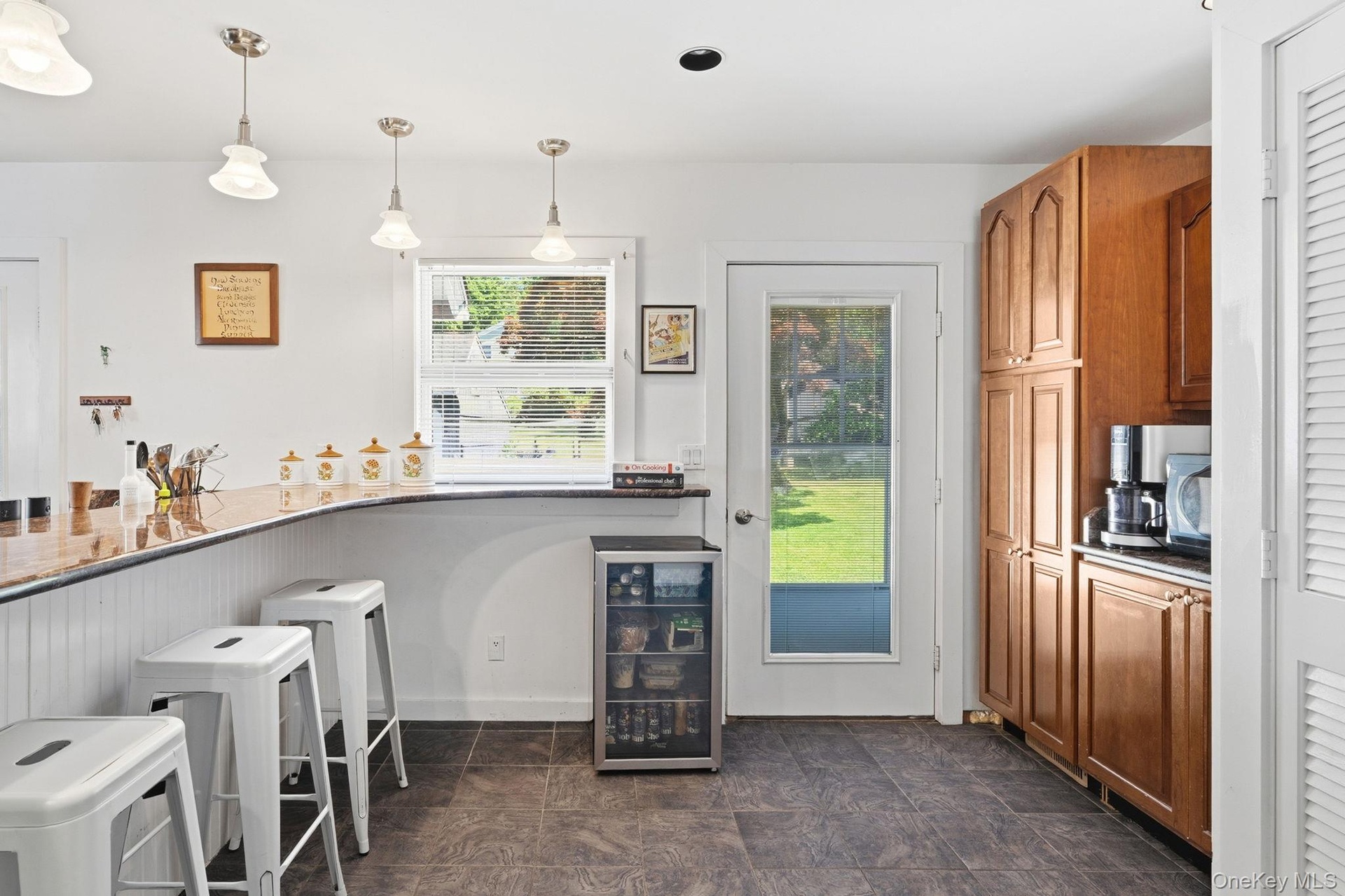 Thoughtfully updated with warm cherry cabinetry, gleaming granite surfaces, stainless steel appliances, a wall oven, and an abundance of pantry storag