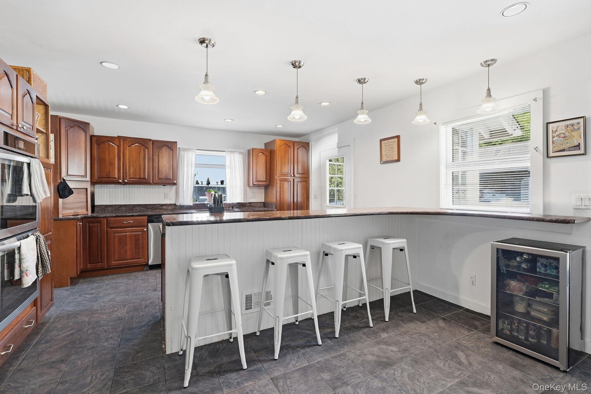 Morning coffee to holiday entertaining, this well-appointed kitchen delivers generous workspace, island seating, extensive cabinetry, and remarkable s