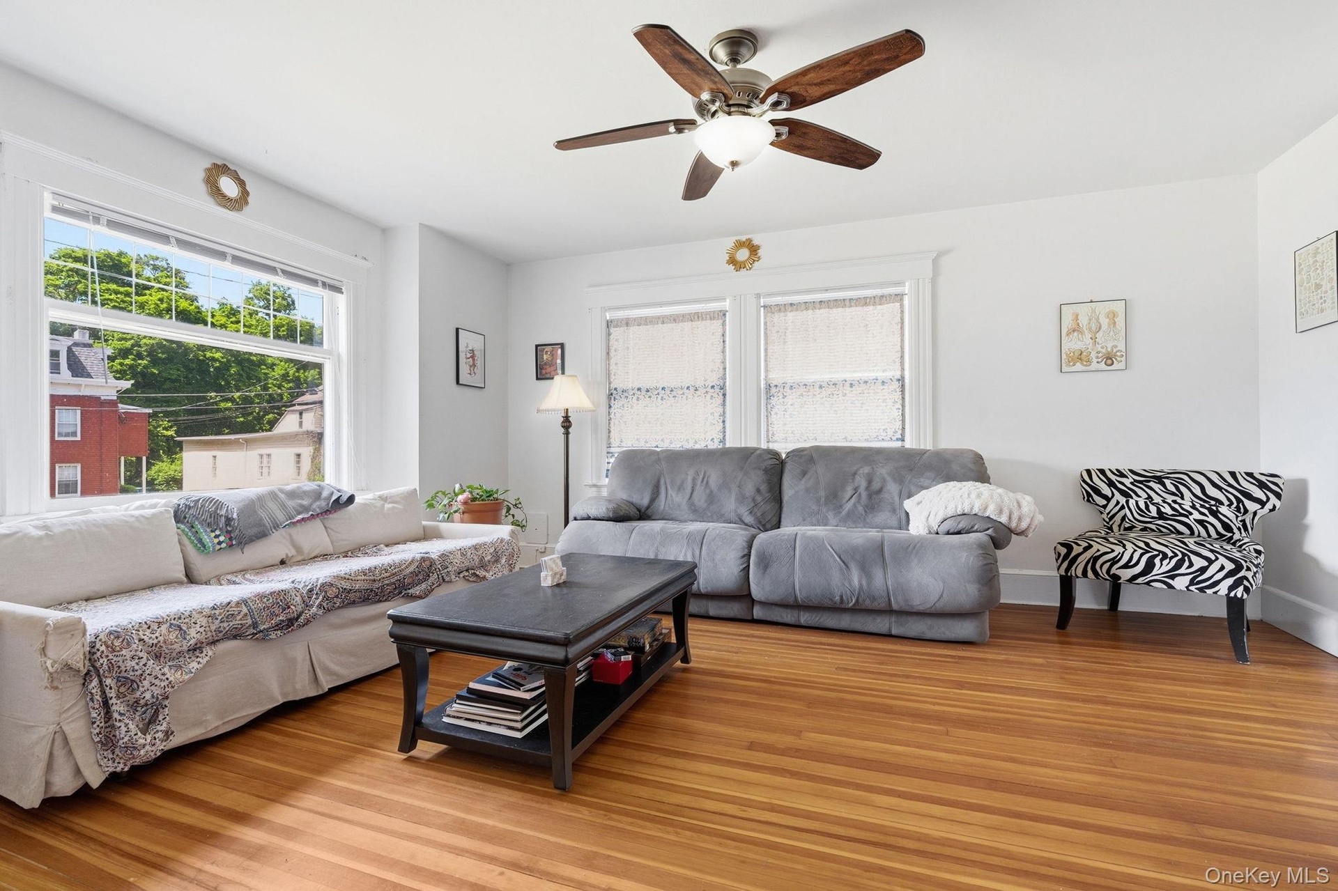 Sunlight pours through expansive windows, filling this spacious living room with warmth and natural beauty.