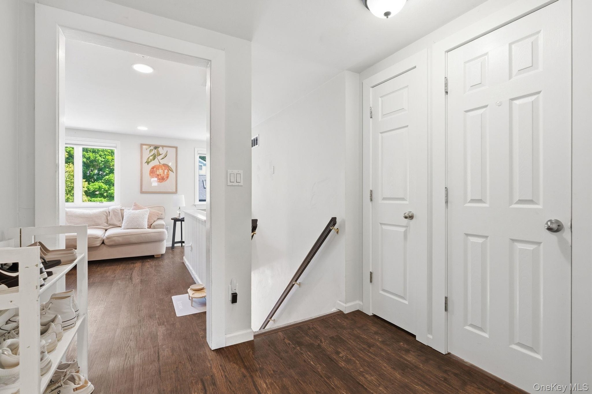 A bright and welcoming second-floor apartment entry featuring a modern, clean aesthetic with immediate appeal.