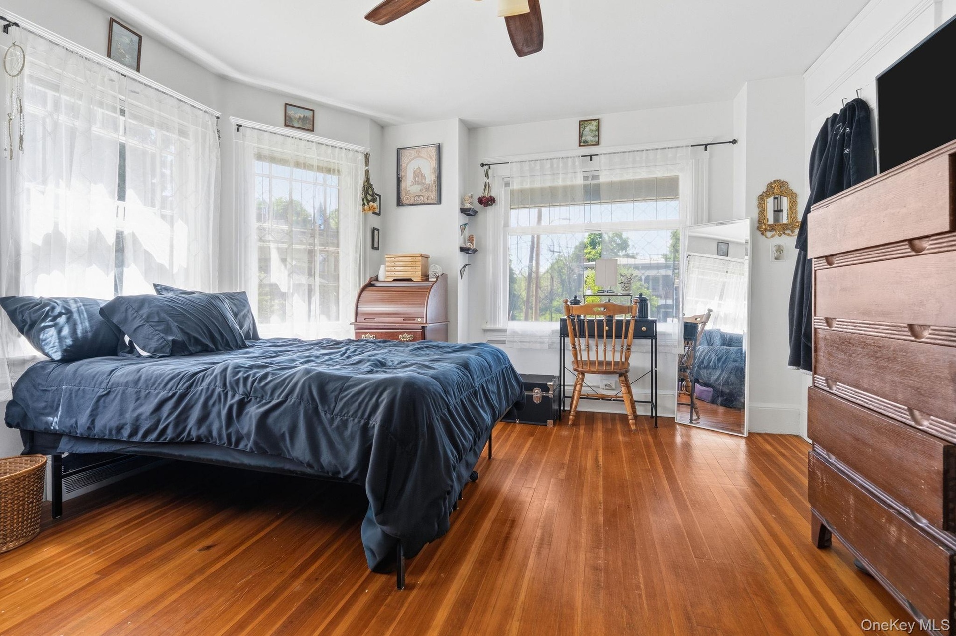 Spacious first-floor bedroom featuring hardwood flooring and ample room for a dedicated workspace or reading nook.