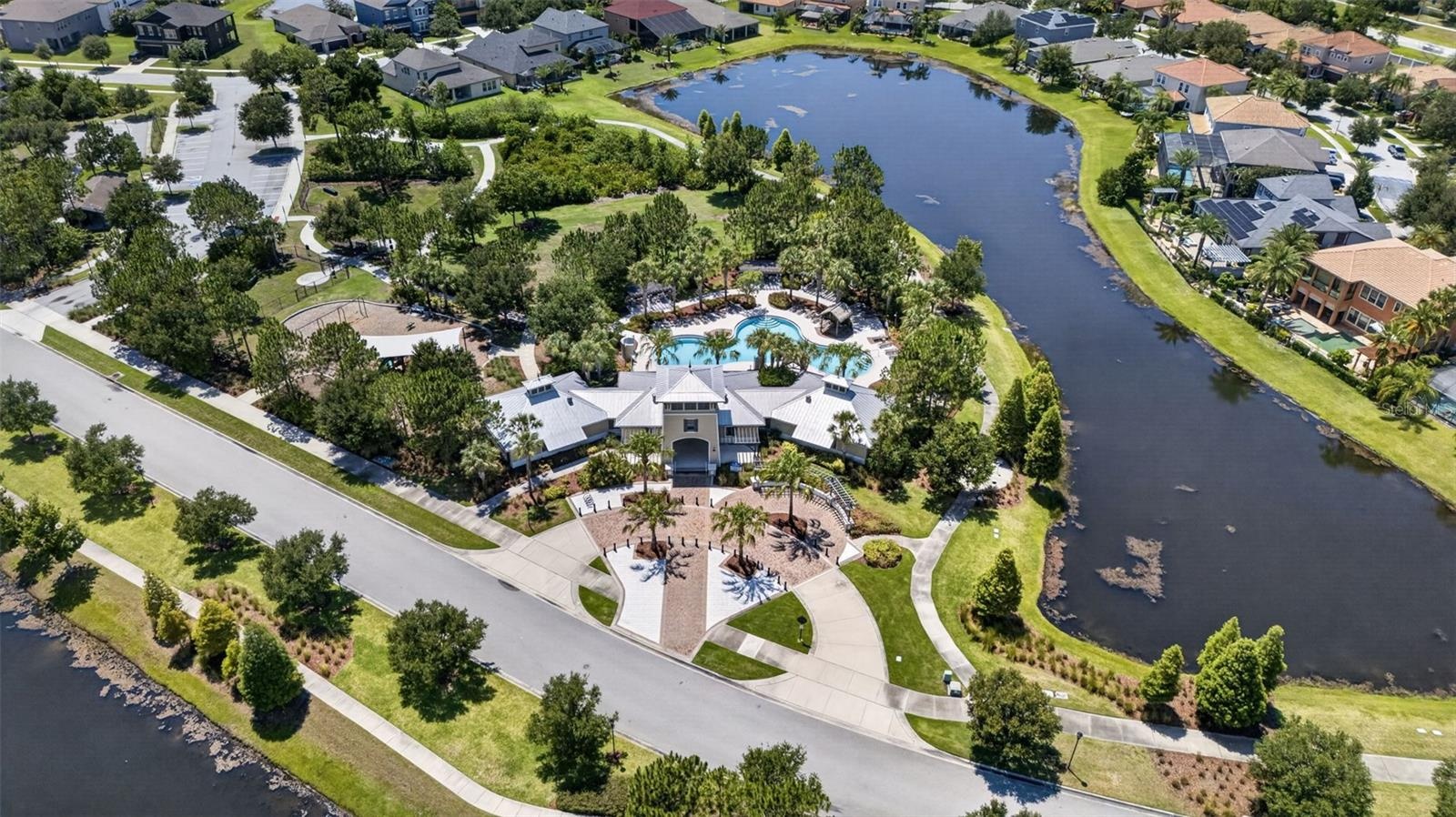 Aerial View of Amenities with Clubhouse, Resort Style Pool, Playground/Park, Sports Court, Dog Park, Walking Trails and Water View in Waterleaf Commun