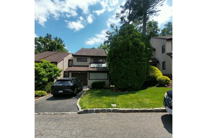Two-story exterior with a shingle roof and tan siding
