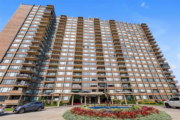 High-rise building featuring a brick facade and numerous private balconies