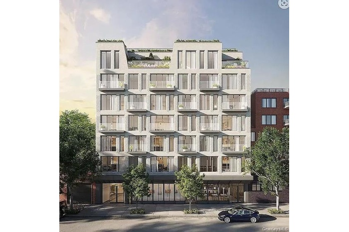 Contemporary multi-story building featuring a light-colored facade with numerous windows and private balconies