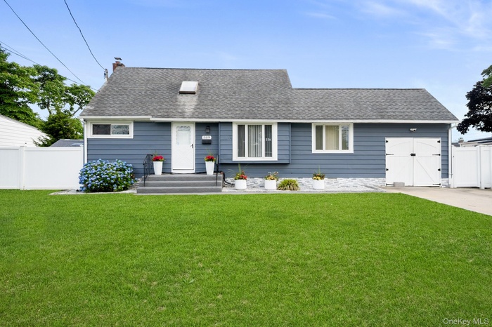 Charming single-story residence featuring blue horizontal siding and a dark shingle roof
