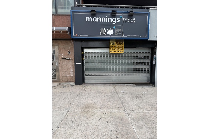 Commercial storefront featuring a roll-down security gate and a prominent illuminated sign