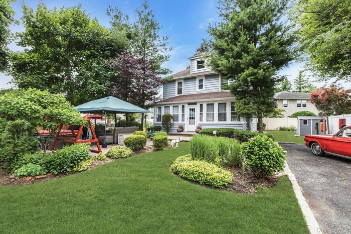 Welcoming front lawn with mature shade trees and established landscaping