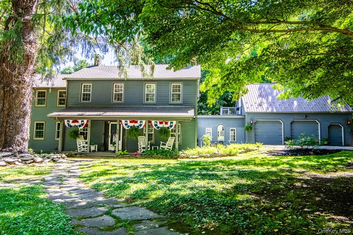 Traditional Colonial Style home has a rocking chair porch and attached 3 car garage