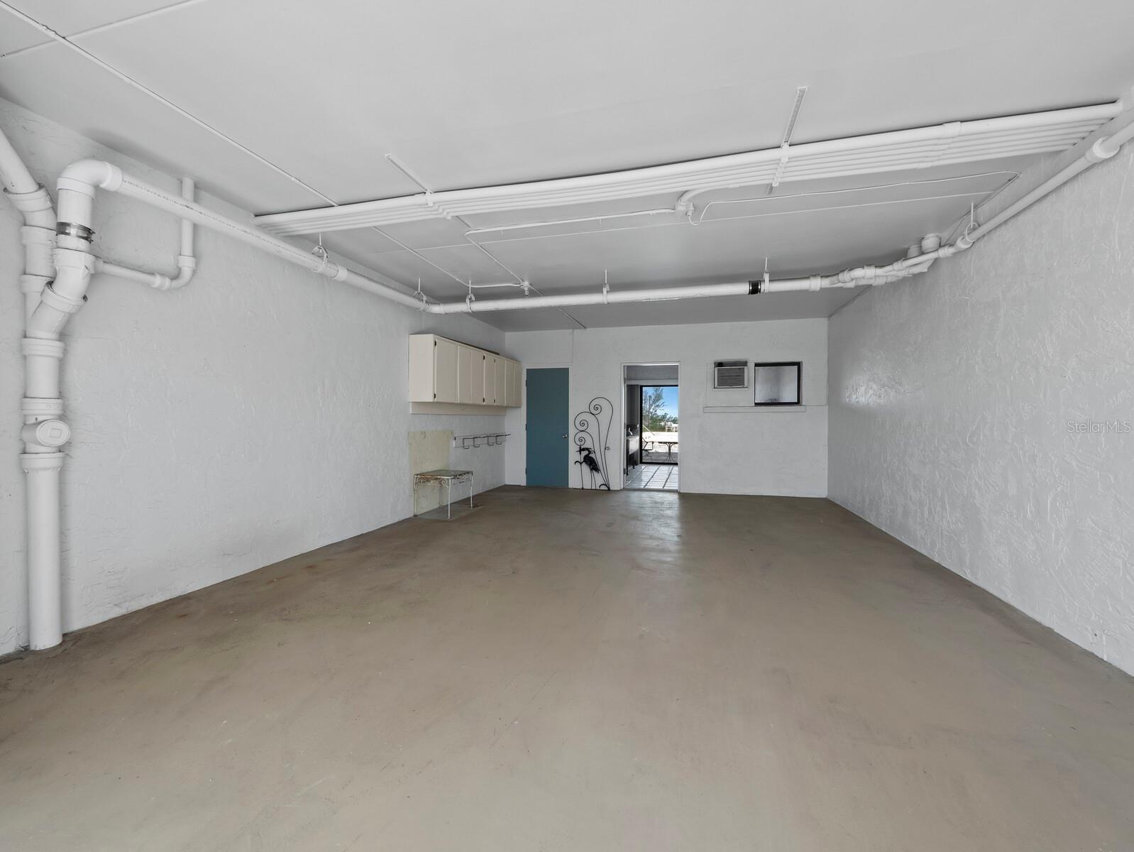 The covered parking with the doors open through the ground floor bonus room