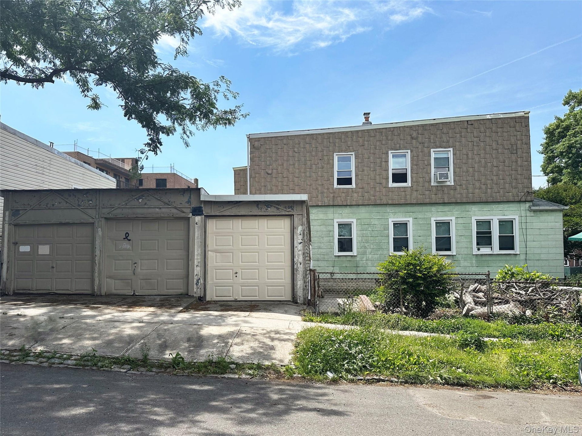 Side of the 2-family building, and 3-car garage.