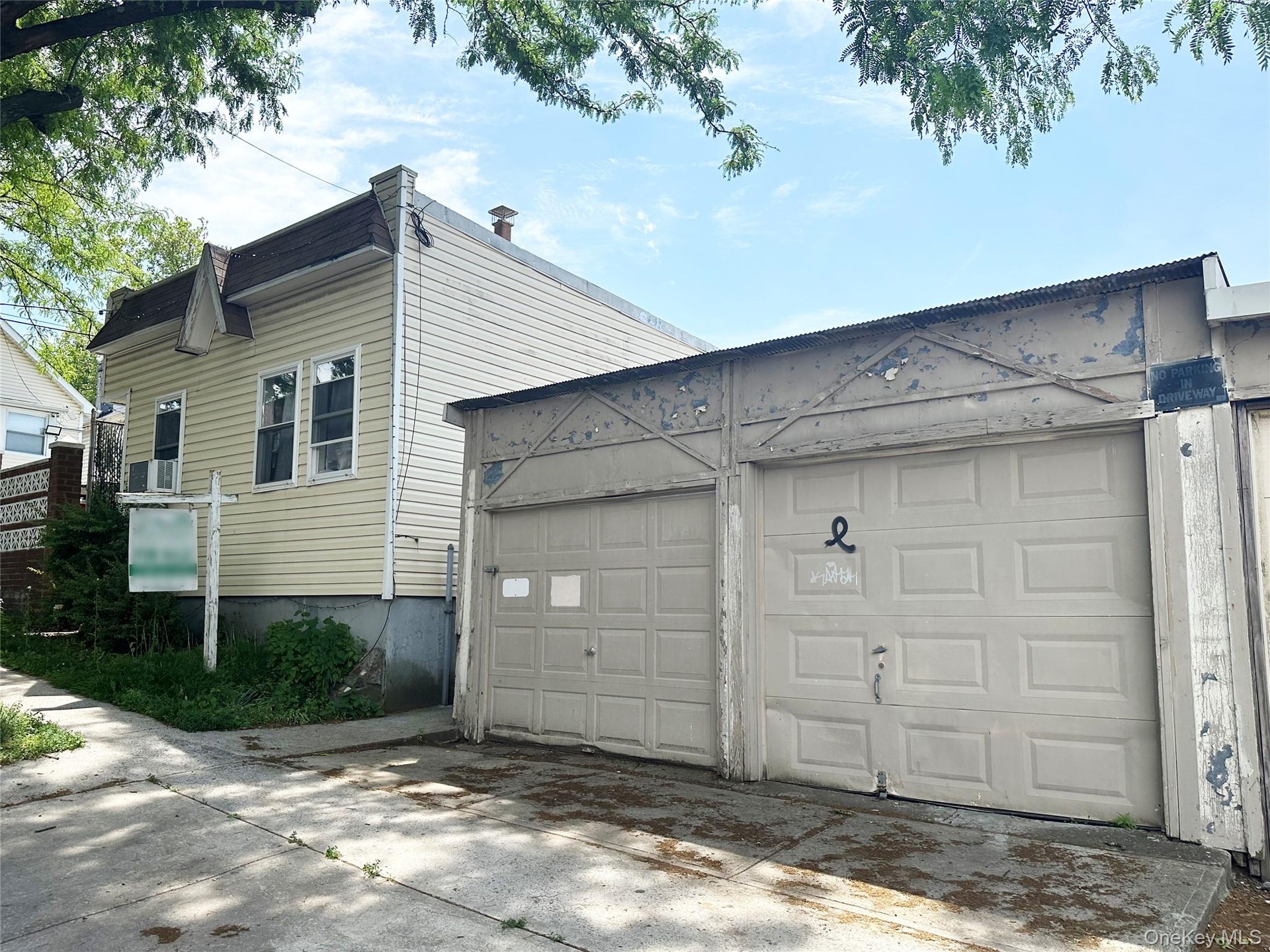 Front of the 1-family building, and part of the 3-car garage.