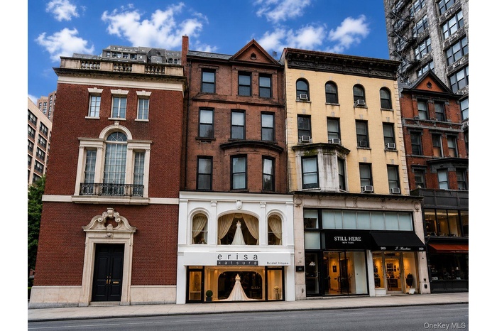 Brick facade building featuring a stone entryway with a double door, a Juliet balcony, and an arched window